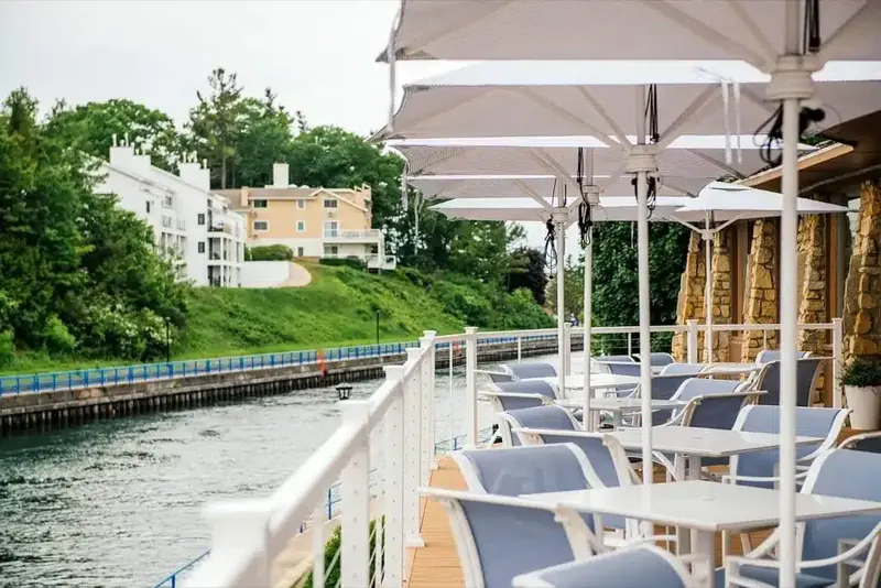 Umbrella shaded tables on the deck above the channel