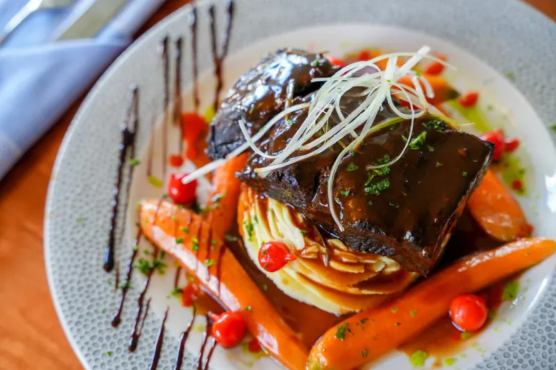 Braised beef plated with roasted carrots
