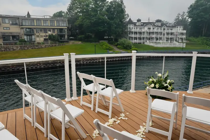 Rows of white chairs set for a ceremony on the waterfront deck